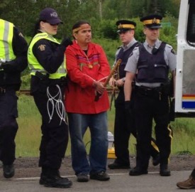 Ron Tremblay, holding sacred pipe, is arrested. Photo courtesy of @1tnb