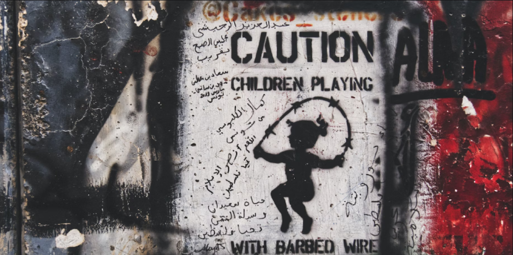 Art on a wall depicting a child playing jump rope. There's some Arabic text around it, along with the title in English, "CAUTION Children playing with barbed wire."
