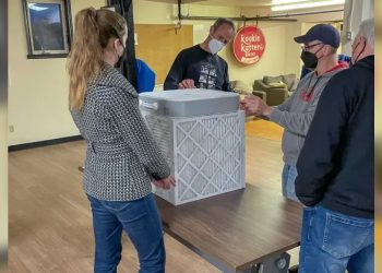 A group of people gathered around an air filter.