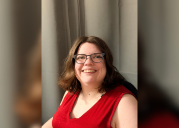 A portrait of Kaitlyn Massey, a disability rights advocate. She is smiling and looking toward the camera.