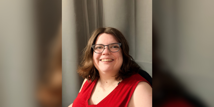 A portrait of Kaitlyn Massey, a disability rights advocate. She is smiling and looking toward the camera.