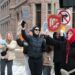 Des manifestants brandissent des pancartes avec les messages « No human is illegal », « ICE out now » et « Stay away from my neighbors » lors d'un rassemblement contre l'ICE au centre-ville de Minneapolis.